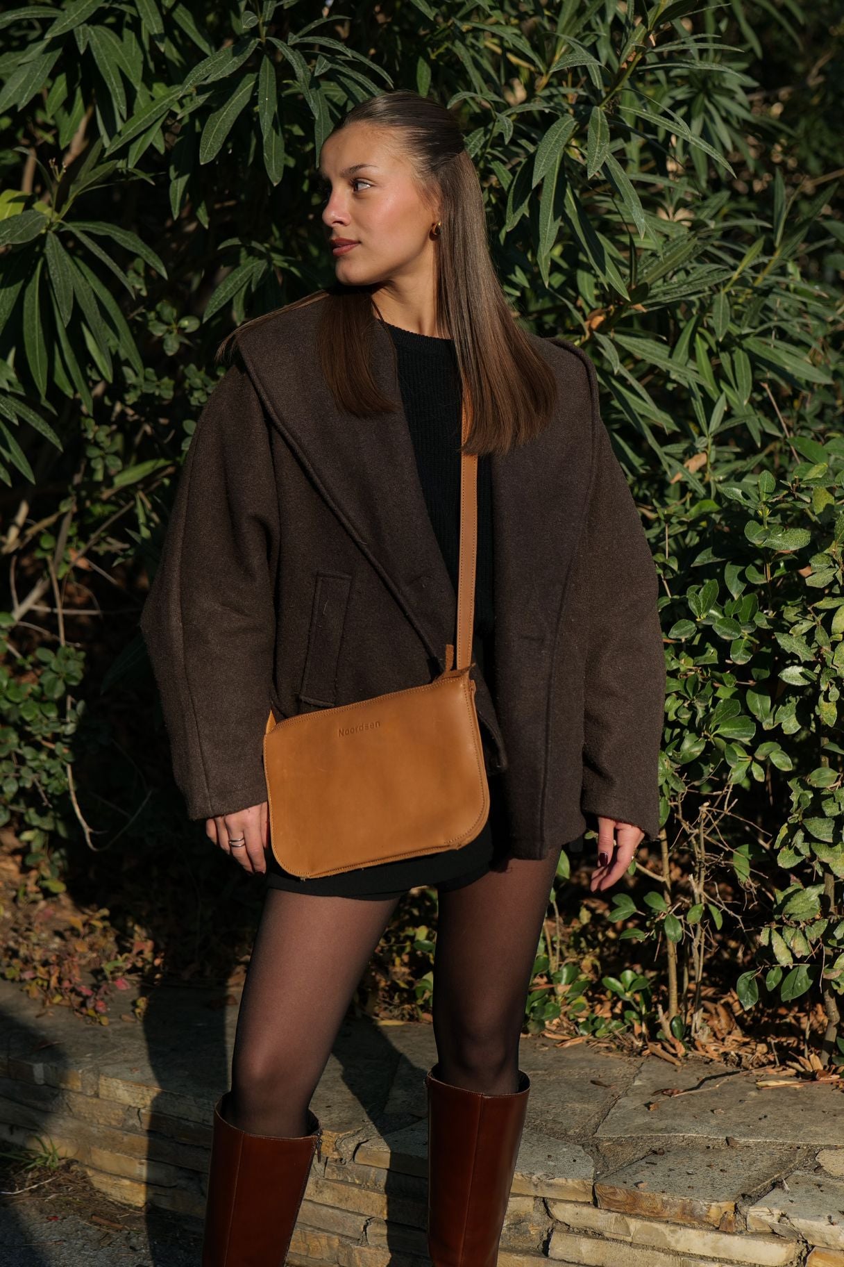 Femme portant le sac bandoulière en cuir cognac Noordsen N003-06 en bandoulière